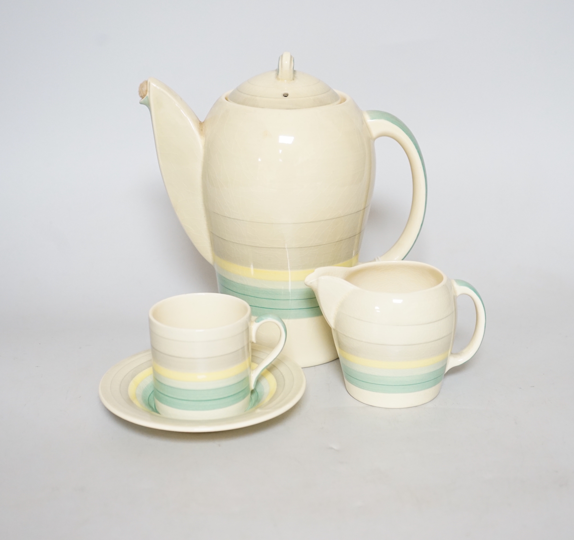 A Susie Cooper coffee set, concentric circles on a cream ground, comprising a coffee pot, milk jug, sugar bowl, five cups and six saucers (14)